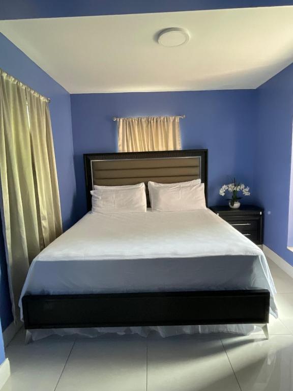 a bedroom with a large bed with blue walls at Sweet Escape Cozy Studio in Fort Lauderdale