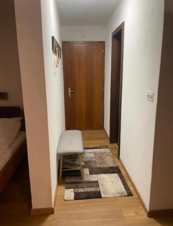 a small hallway with a stool and a door at Studio, proche des pistes et des commerces in Vionnaz