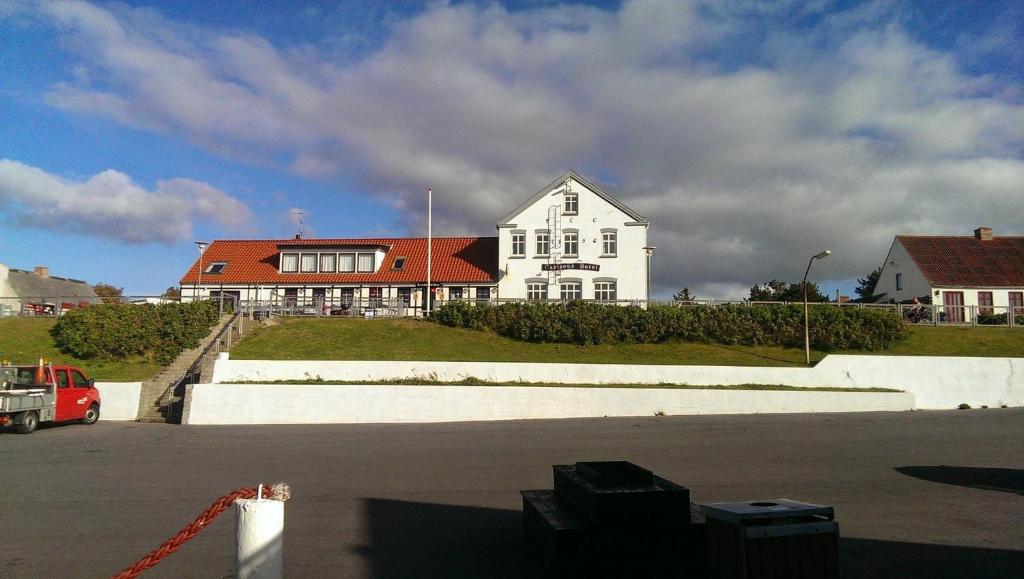 a large white house with a red roof at carlsens hotel in Vesterø Havn