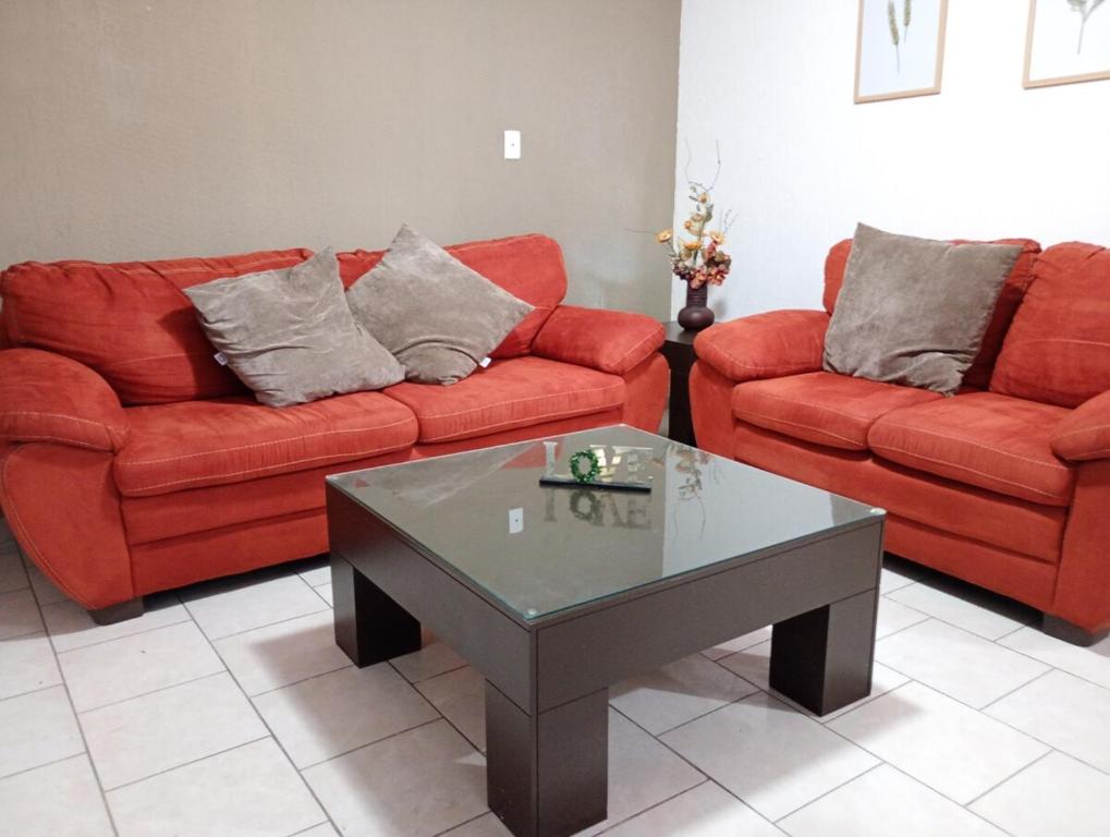 a living room with two red couches and a coffee table at Casa en altos colonia lomas SLP in San Luis Potosí