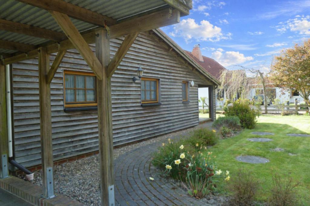 a wooden house with a brick walkway in front of it at Diekkieker in Wurster Nordseeküste