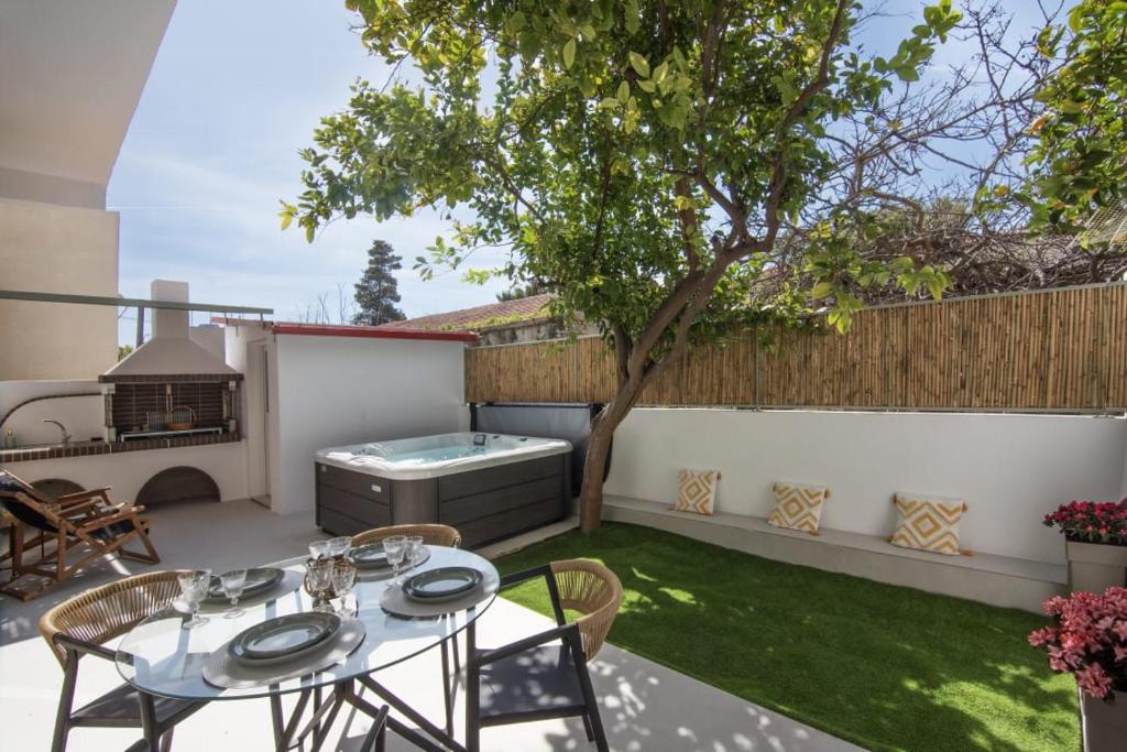 a patio with a table and chairs and a grill at Joanna Holiday Home in Egina