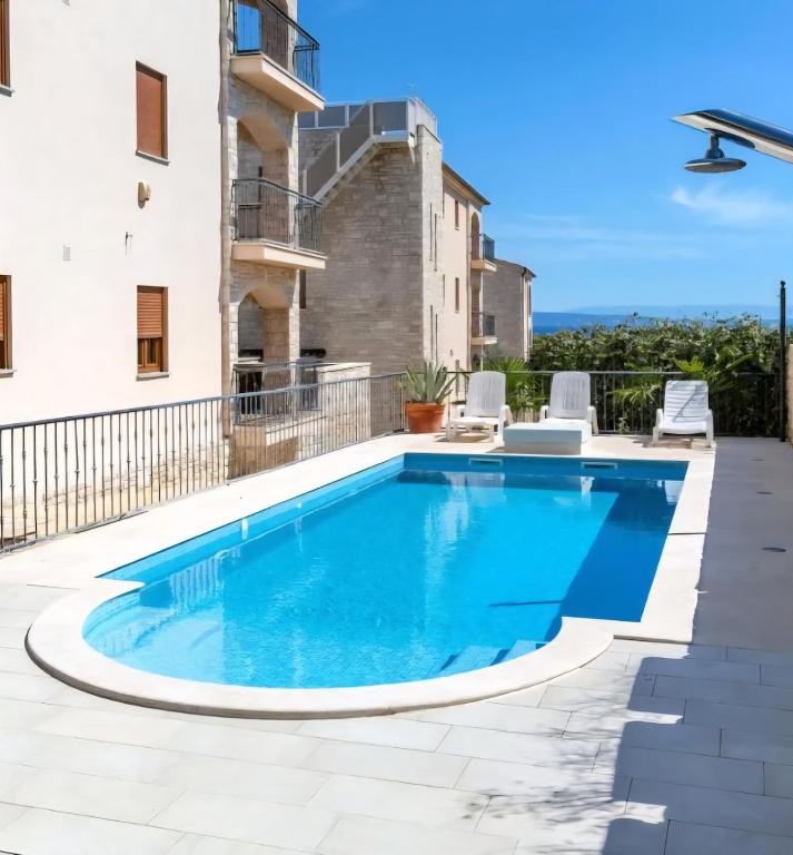 a swimming pool on the patio of a house at R&G Serenity Apartment in Ližnjan