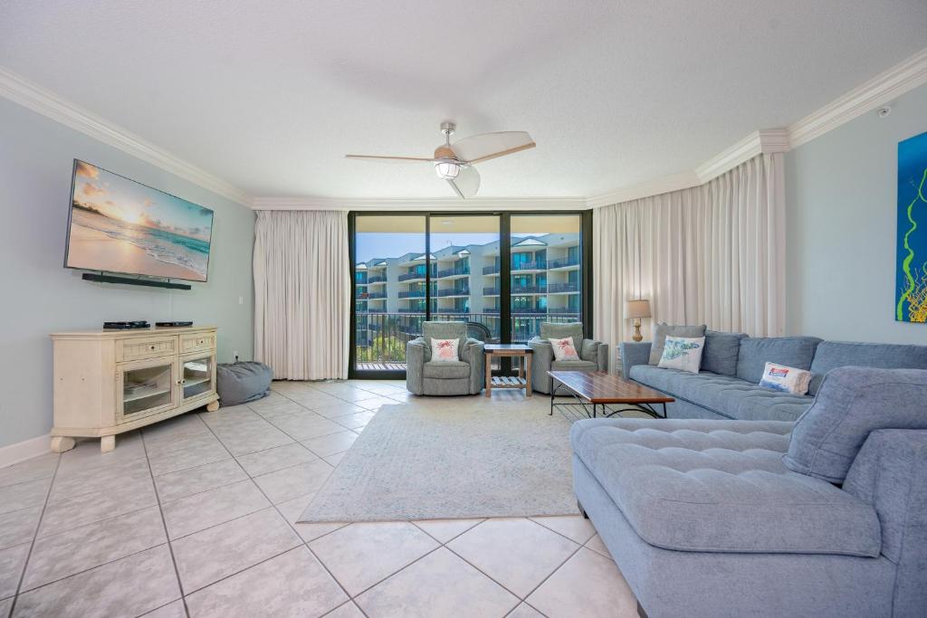 a living room with a couch and a tv at Phoenix on the Bay 1326 condo in Orange Beach