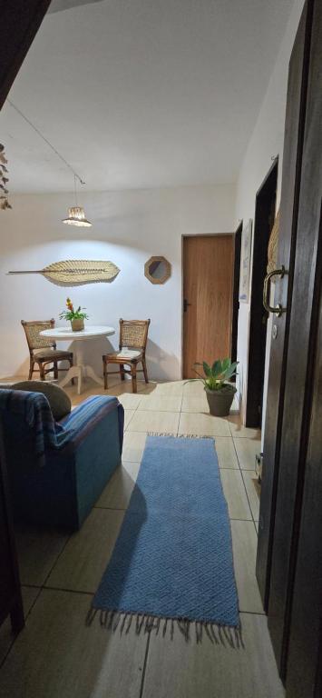 a living room with a blue rug and a table at Casa Manga Rosa in Paraty