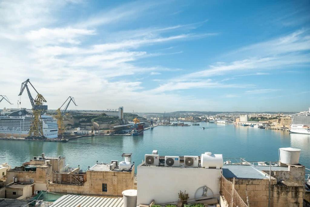 a view of a river with buildings and cranes at Senglea Charming 2BDR Townhouse in Senglea