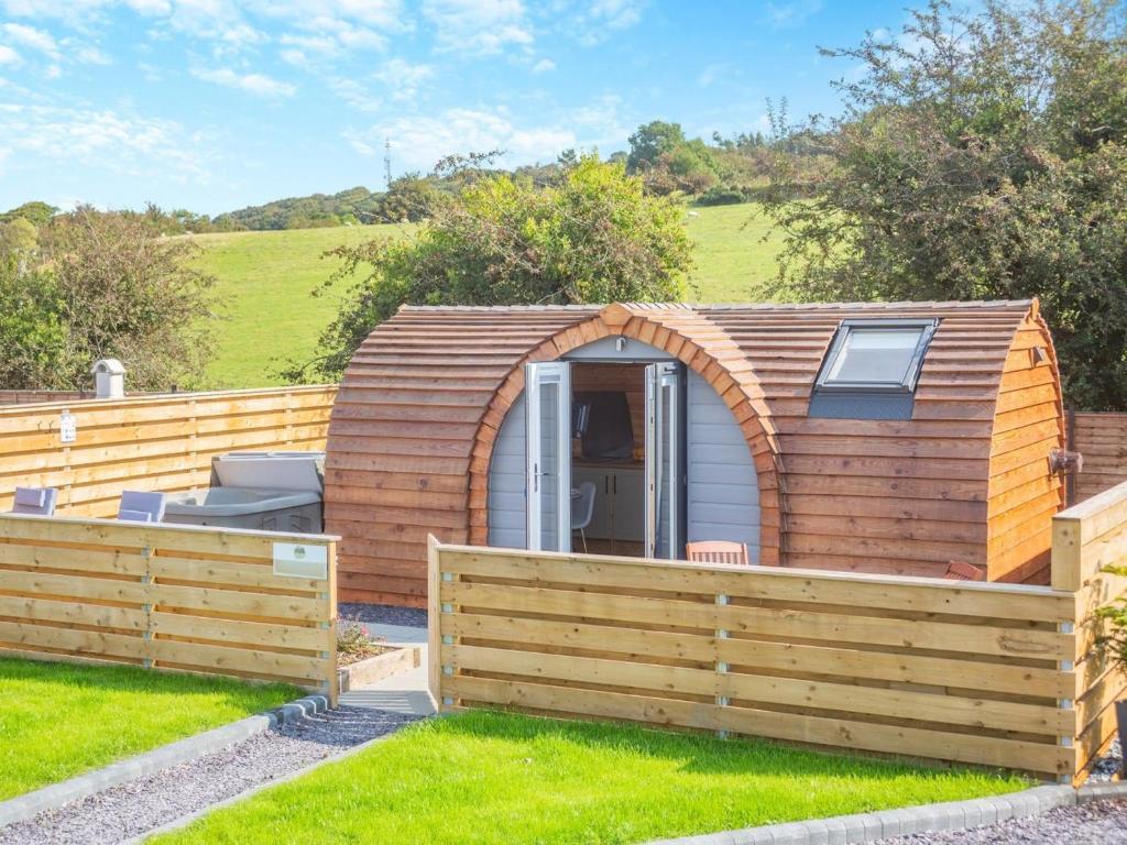 a small wooden shed with a wooden fence at 1 Bed in Conwy oc-95222 in Conwy