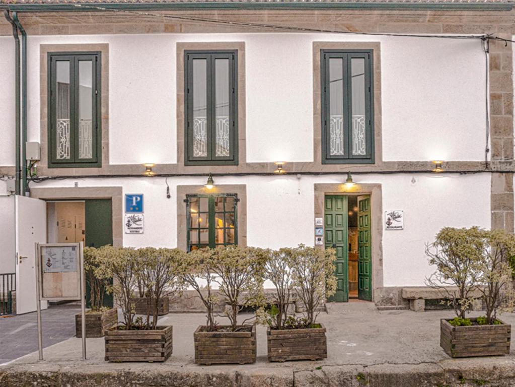 a white building with plants in front of it at A Casa do Tella e Rosalía in Portosin