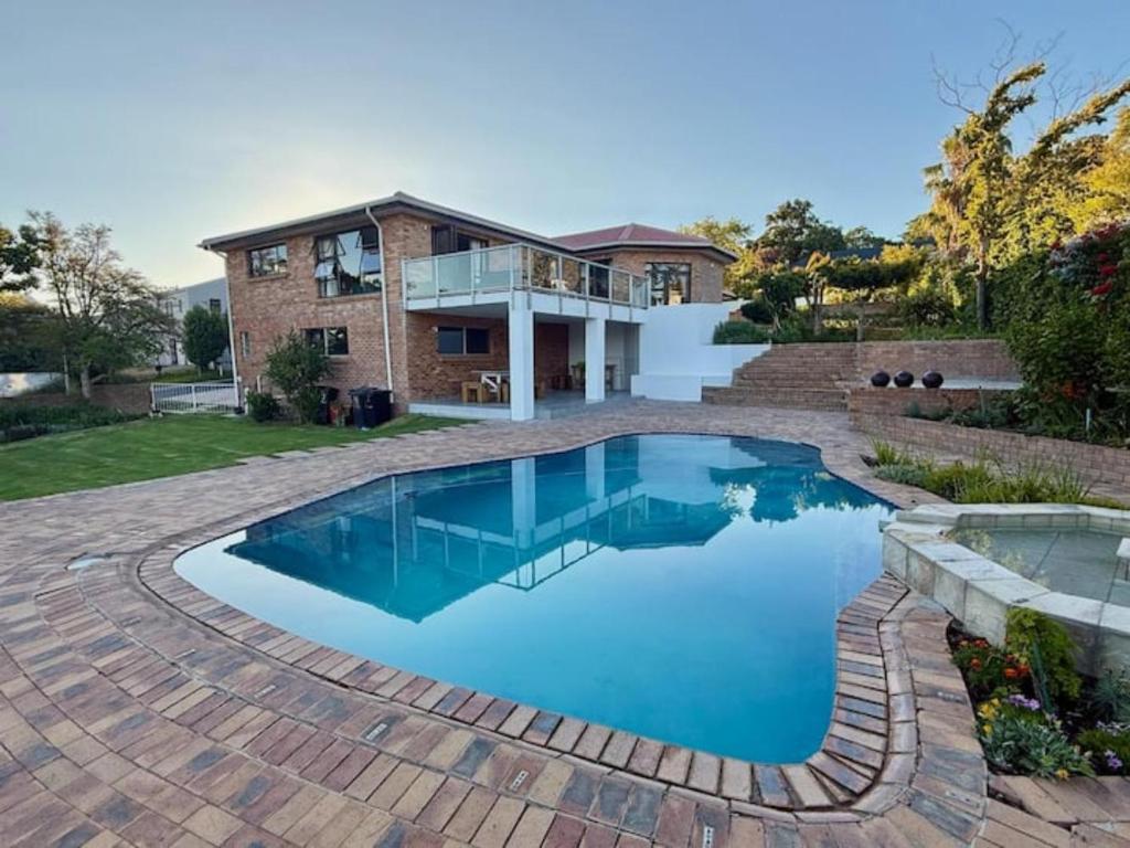 a swimming pool in front of a house at Pearl Vista in Somerset West