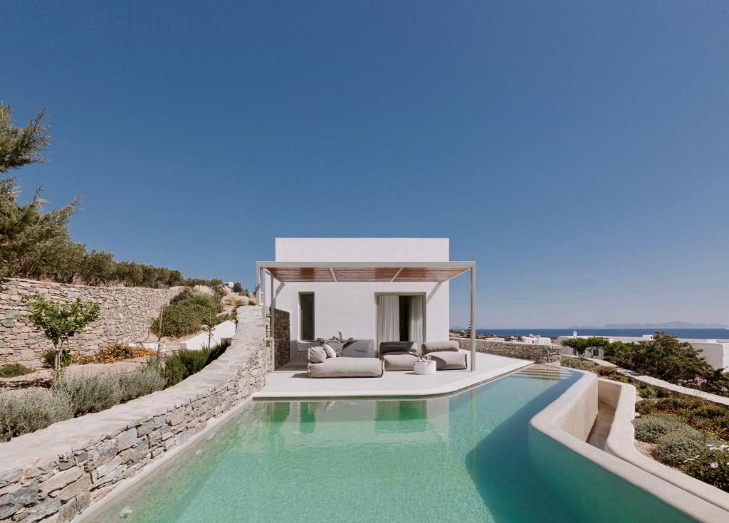 a villa with a swimming pool and a house at Melora Villas Paros in Aliki