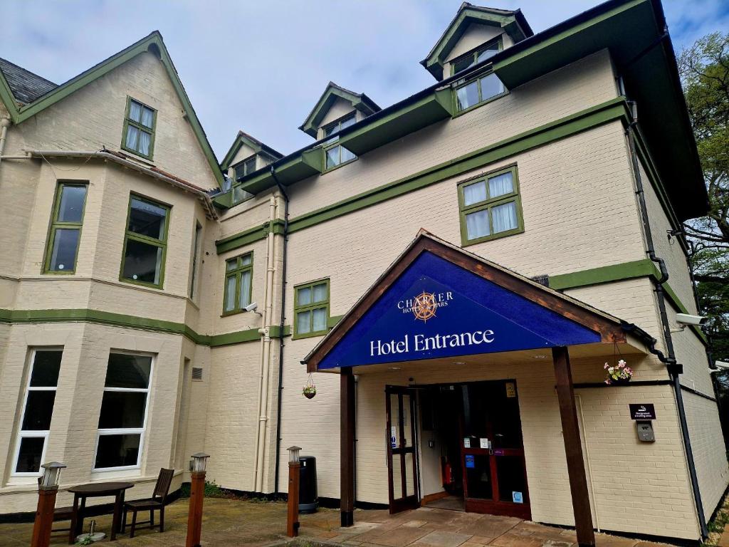a large building with a blue sign in front of it at Charter Hotel Bournemouth in Bournemouth