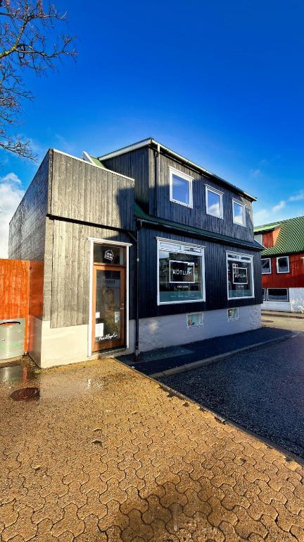 a black building with a door on a street at Penthouse Apartment with Balcony in City Centre and Private Parking in Tórshavn