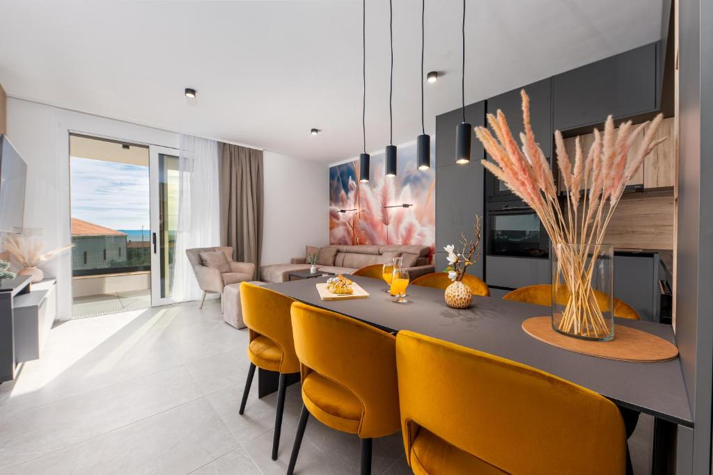 a dining room with a table and yellow chairs at Sunshine Breeze in Promajna