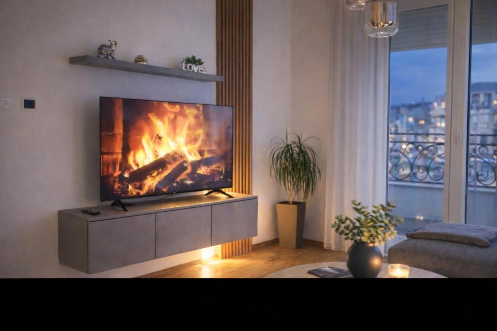 a living room with a fire on the tv at Apartman River in Bijeljina