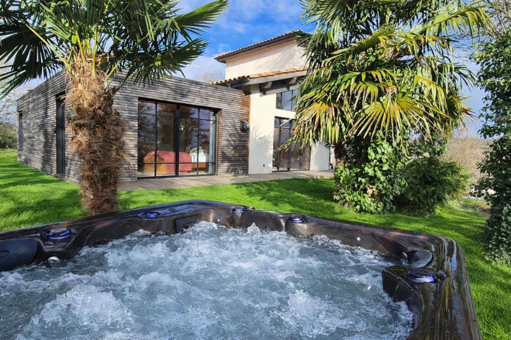 a hot tub in a yard next to a house at Chez Cécile et Marco in Moissac