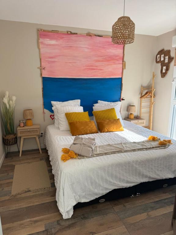 a bedroom with a large bed with a blue headboard at Hearttoart in Martigues