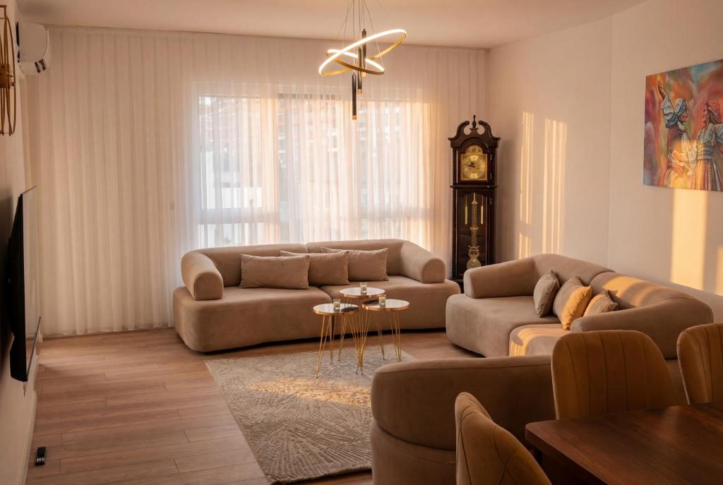 a living room with a couch and a clock at Inviti Apartments in Gjakove