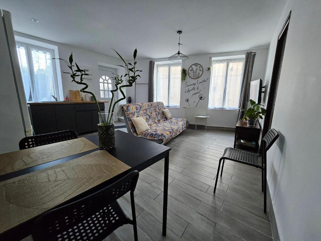 a living room with a table and a chair at Le CASTEL 22 in Châteaumeillant
