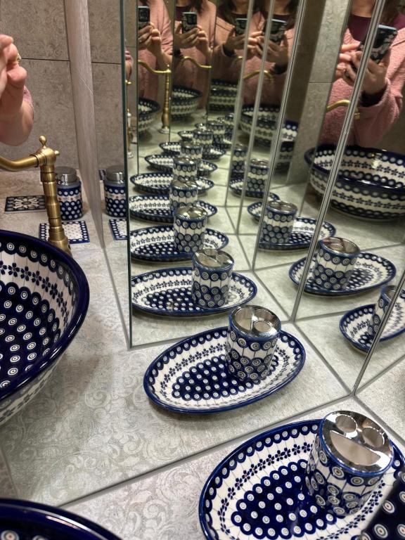 a group of blue and white plates and cups on a counter at Pottery Town Center Apartment in Bolesławiec