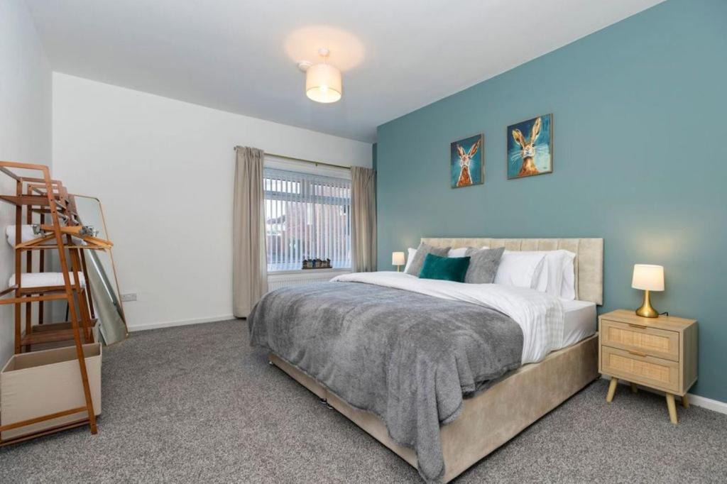 a bedroom with a bed with a blue wall at Durham 5BR Contractors Long Stay Discounts in Murton