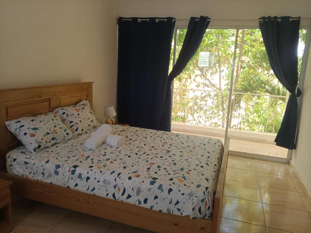a bedroom with a bed and a large window at MK apartment in Las Terrenas