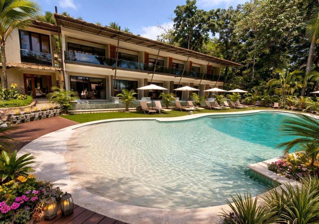 a swimming pool in front of a house at Miamar in Manuel Antonio