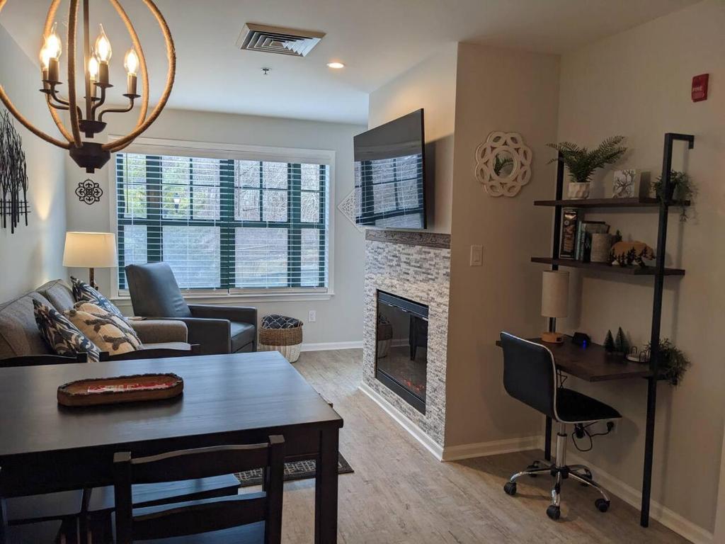 a living room with a table and a fireplace at All New Chic Ski inout King bed in Vernon Township