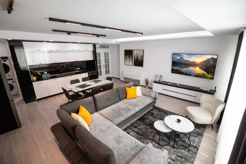 a living room with a gray couch and yellow pillows at DEX Apartment Korca in Korçë