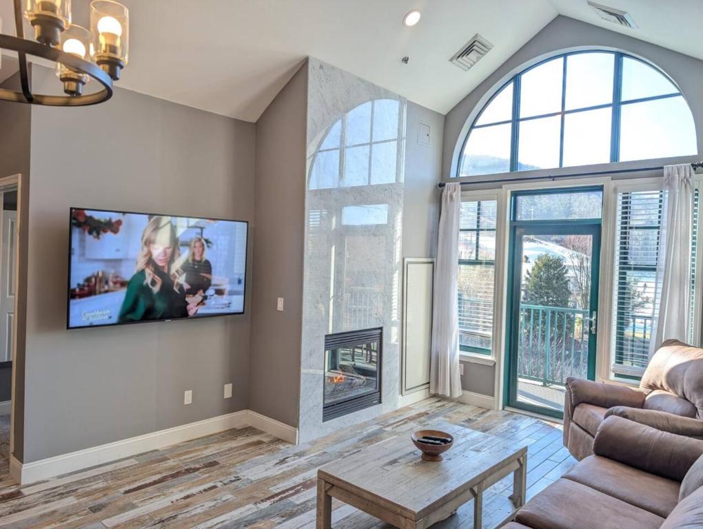 a living room with a couch and a tv on a wall at 2 Bed Top Flr Prem Penthouse Suite in Vernon Township