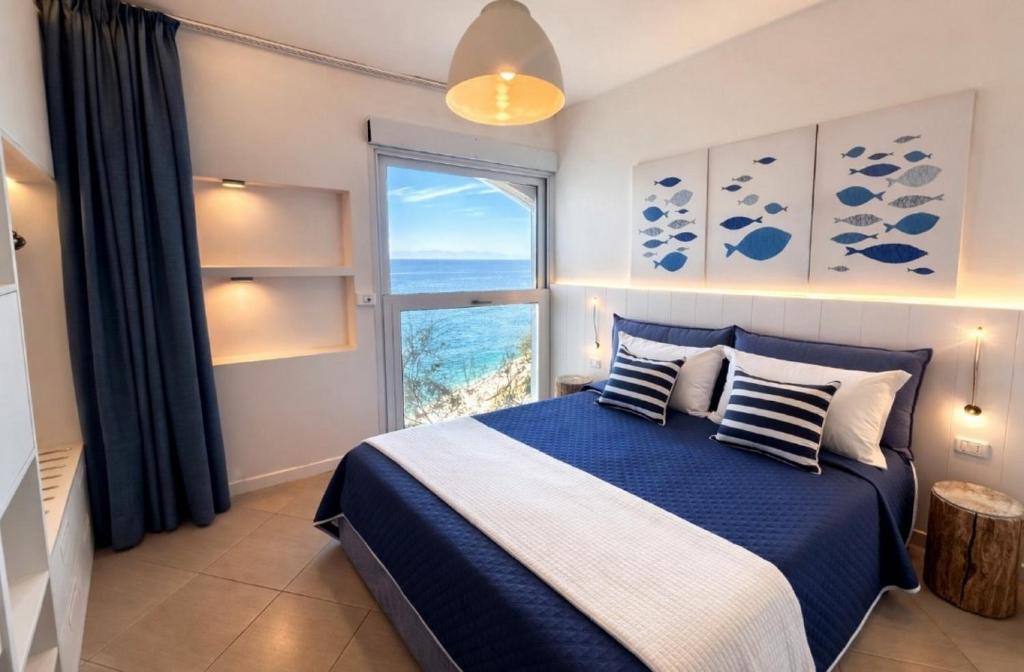 a bedroom with a bed and a large window at Casa Pomonte in Pomonte