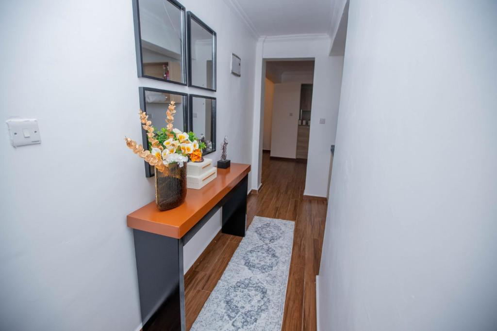 a hallway with a table with a vase of flowers on it at The Prestige Hub Residences in Eldoret