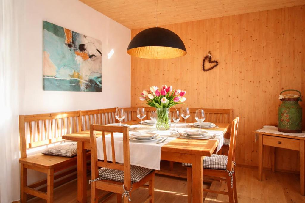 a dining room with a table with a vase of flowers at ChiemseeRefugium - Ferienwohnung Berg in Bernau am Chiemsee
