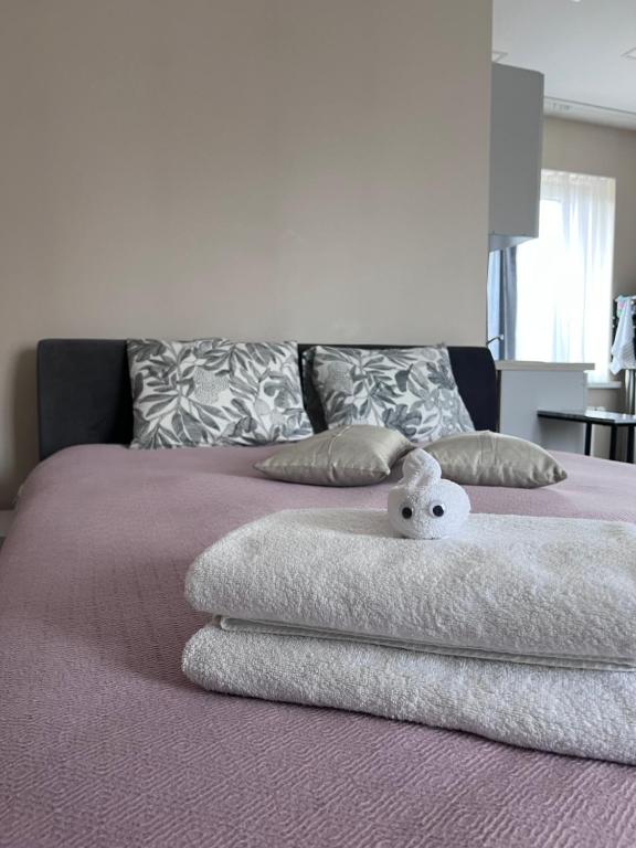 a bed with towels and a stuffed animal on it at Straumes apartamenti in Valmiera