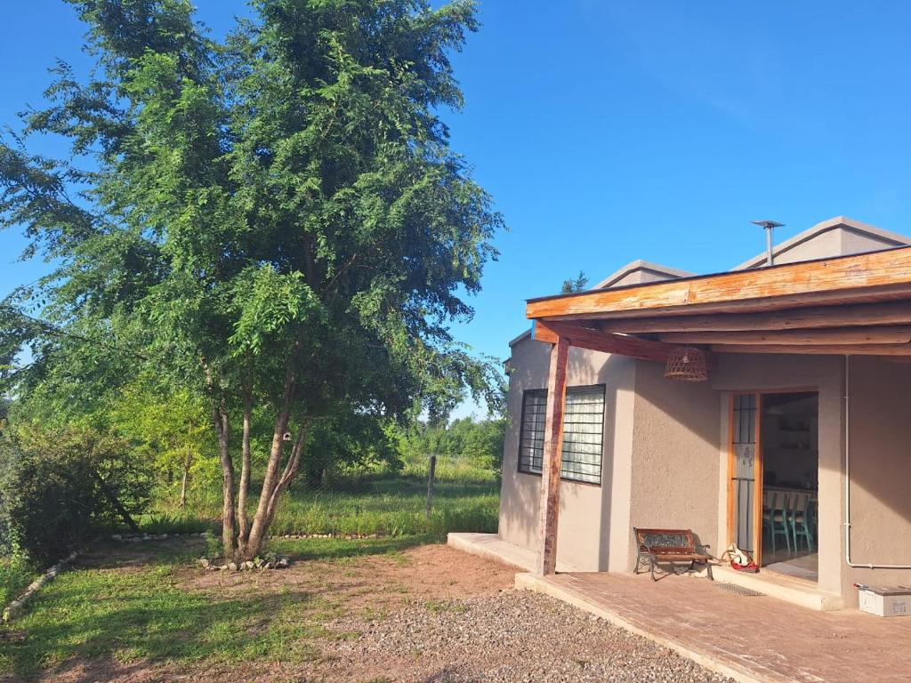 a house with a tree and a bench next to it at HastaLaRaíz-LosReartes in Los Reartes