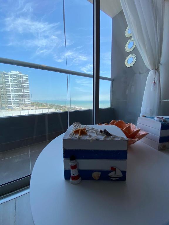 a cake sitting on a table in front of a window at San Miguel Apartment Ocean Magic in Lima