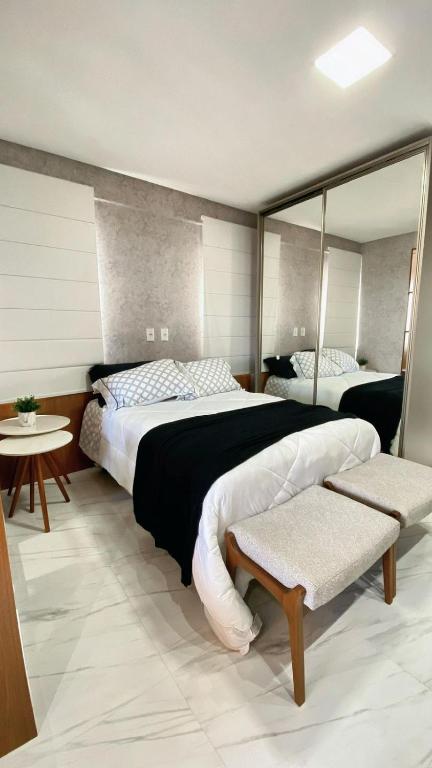 a bedroom with two beds and a mirror at Loft sua morada in Capão da Canoa