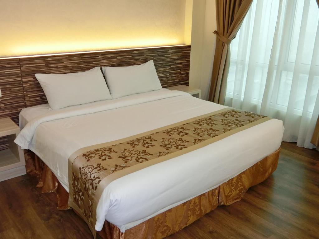 Postel nebo postele na pokoji v ubytování MidCity Hotel Melaka