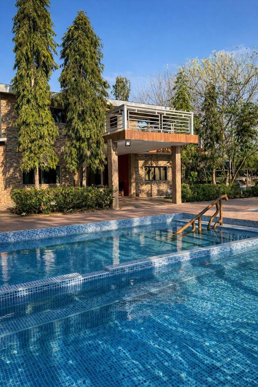 a swimming pool in front of a building with a house at Hotel Termaland in Atiquizaya