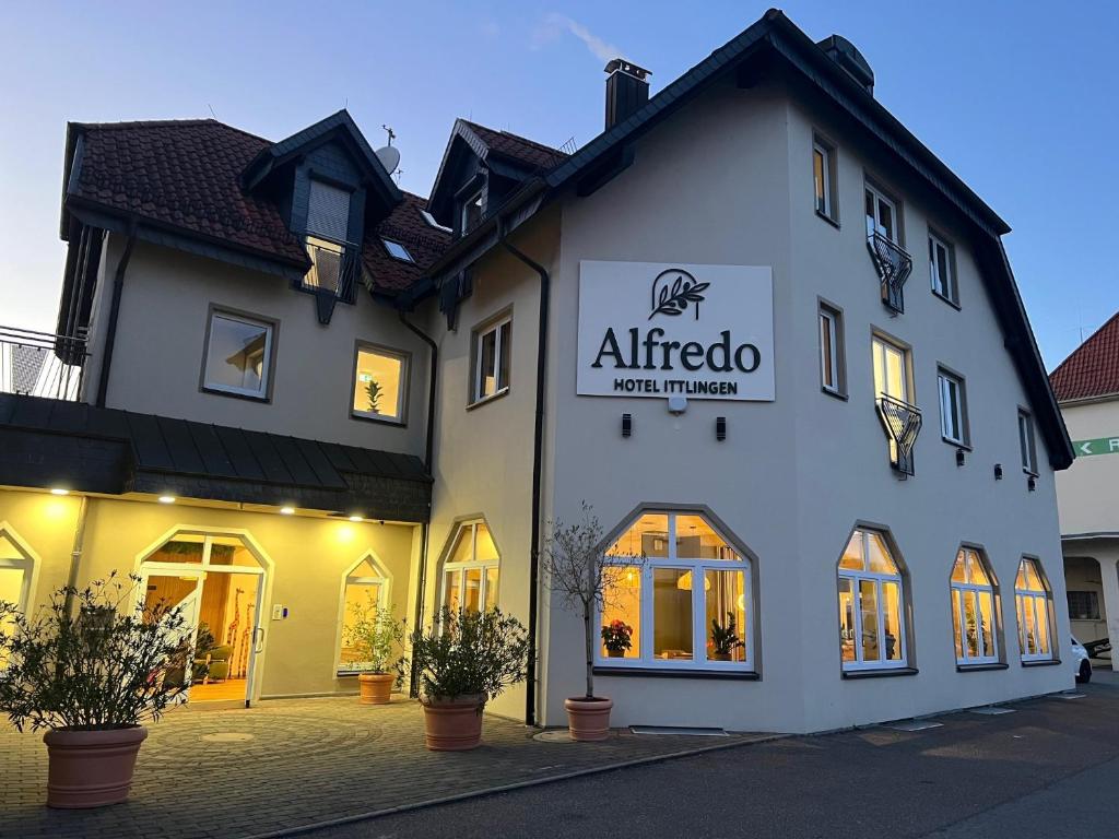 a white building with a sign on the front of it at Alfredo Hotel in Eppingen