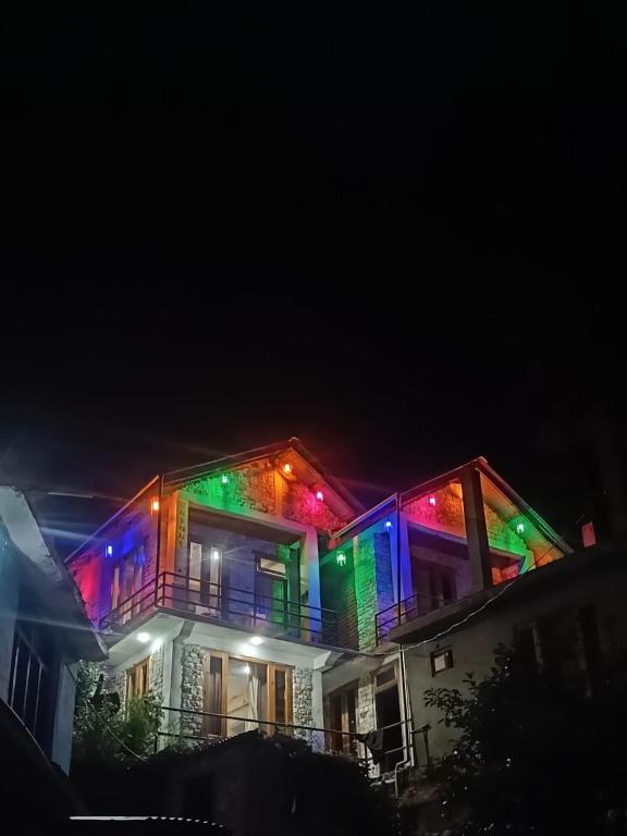 a house with colorful lights on the side of it at tirthan horizon homestay in Banjār