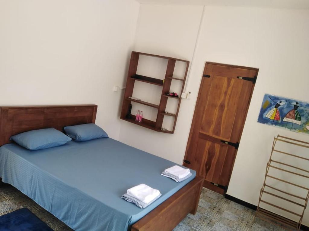 a bedroom with a bed and a wooden door at Evara Homestay in Monaragala