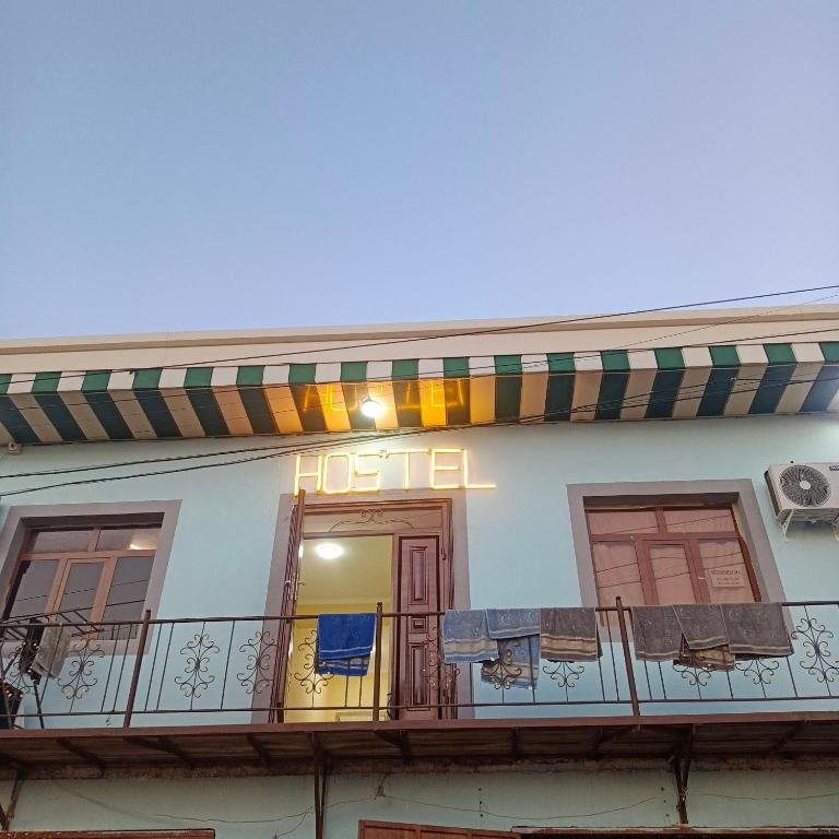 a hotel with a balcony with chairs on it at Bro Hostel Angor in Termiz