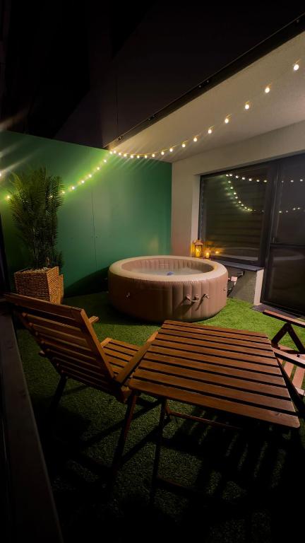 a large bath tub in a room with a bench at AH Radnica Spa Jacuzzi , Home Theatre in Košice
