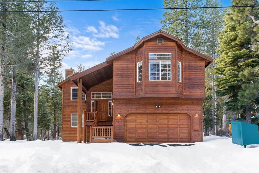 a wooden house with a garage in the snow at Cascade Woods in Tahoma