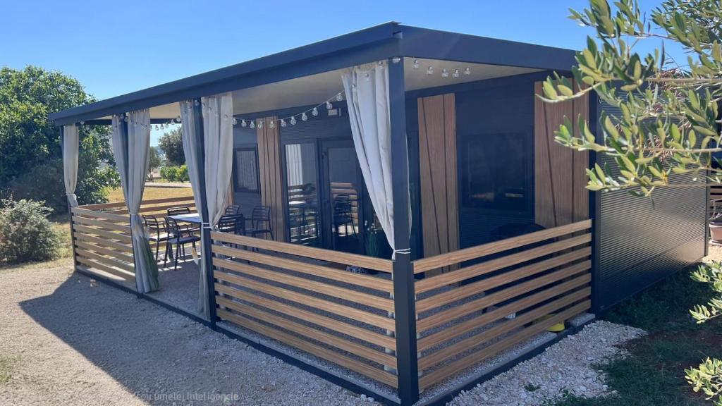 a screened in gazebo with a table and chairs at Vila Mia 3, camp Limoni in Sukošan