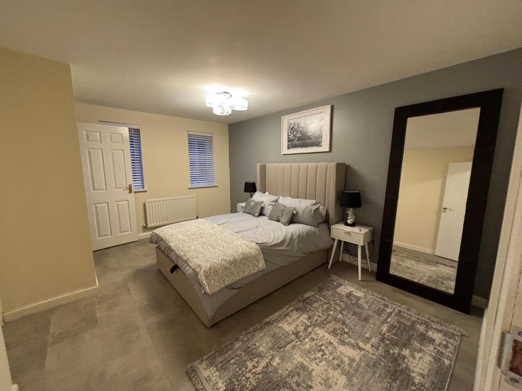 a bedroom with a bed and a large mirror at Haven at Chafford Hundred in West Thurrock