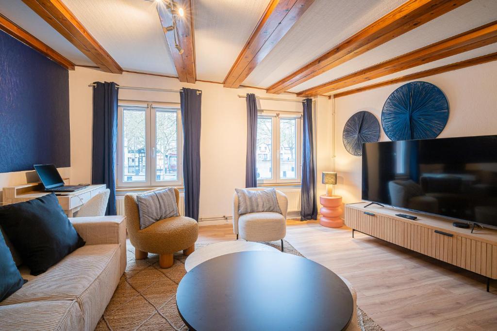 a living room with a couch and a flat screen tv at SBredele - Maison de ville cosy - hypercentre in Sélestat