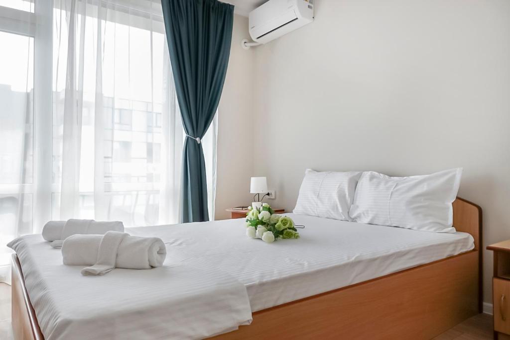a bedroom with a white bed with flowers on it at Solea Family Hotel & Restaurant l Free Parking in Ravda