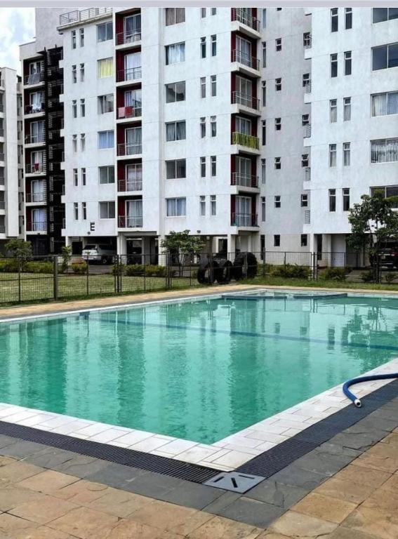 a large swimming pool in front of tall buildings at HM Royal Homes in Nairobi