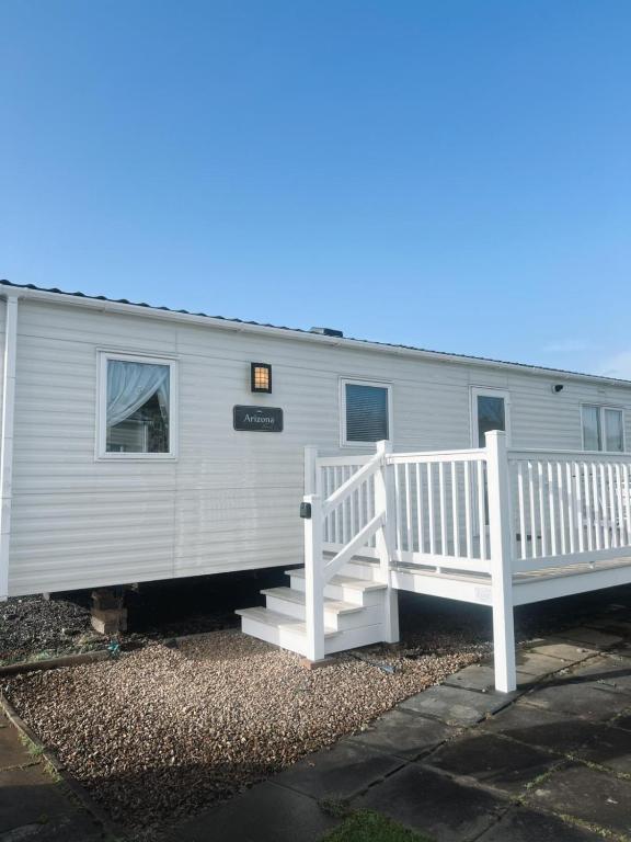 a mobile home with a white porch and stairs at St Nicolas in Girvan